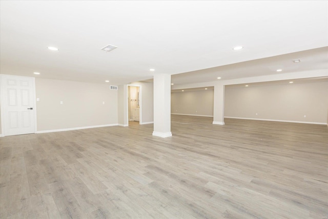 basement with light hardwood / wood-style flooring