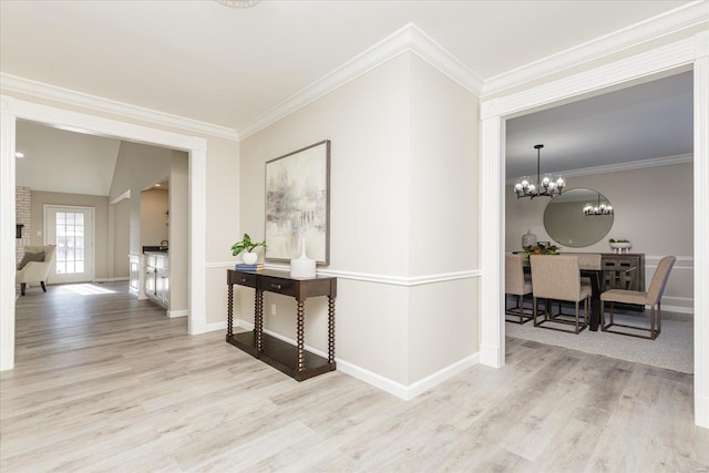 corridor with vaulted ceiling, crown molding, a chandelier, and light hardwood / wood-style flooring