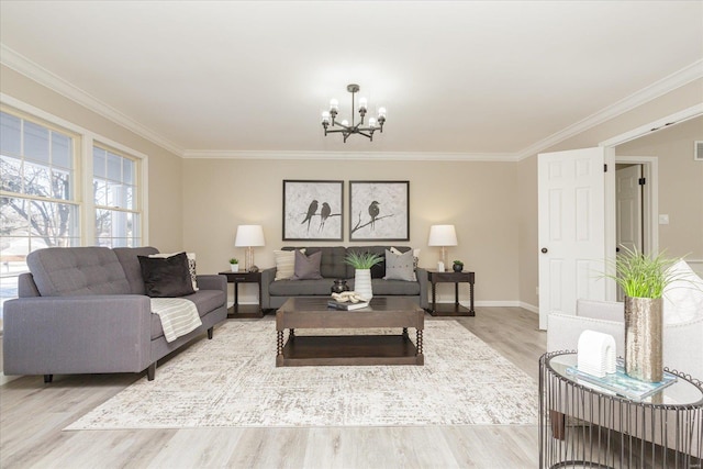 living room with an inviting chandelier, ornamental molding, and light hardwood / wood-style floors