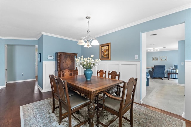 dining room featuring crown molding, hardwood / wood-style floors, and a chandelier