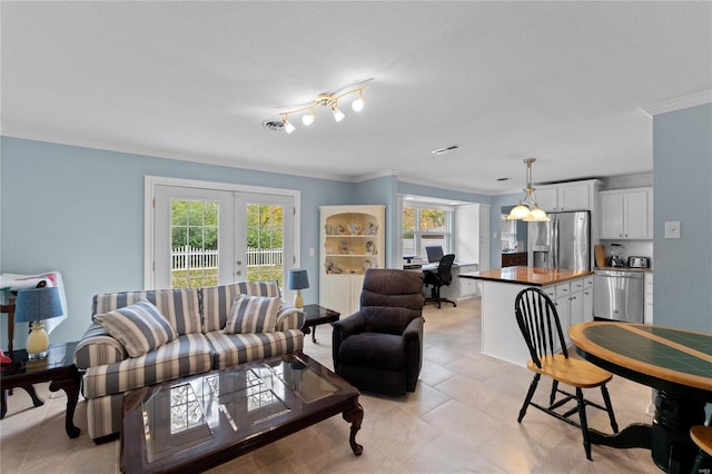 tiled living room with ornamental molding, a textured ceiling, a wealth of natural light, and french doors