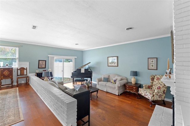 living room with a fireplace, hardwood / wood-style flooring, a wealth of natural light, and crown molding