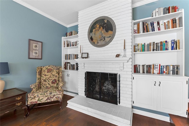 sitting room with dark hardwood / wood-style floors, ornamental molding, and a brick fireplace