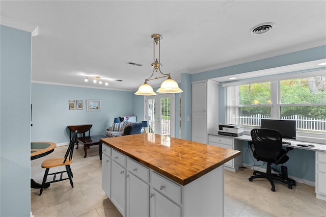 kitchen with white cabinetry, wood counters, crown molding, decorative light fixtures, and a kitchen island