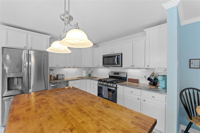 kitchen with white cabinets, decorative light fixtures, backsplash, and stainless steel appliances