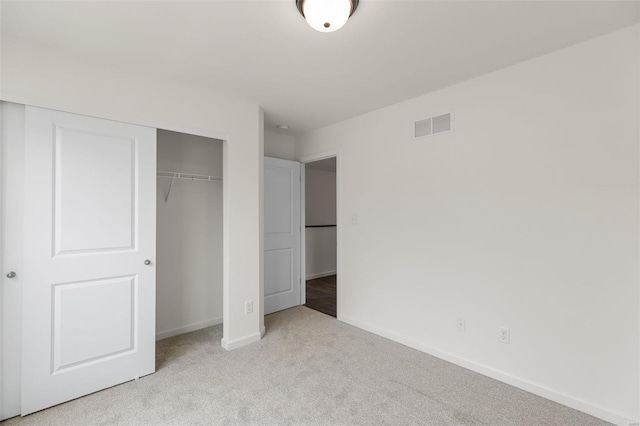 unfurnished bedroom featuring light colored carpet and a closet