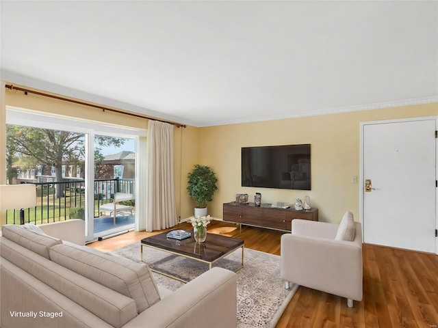 living room featuring hardwood / wood-style flooring and ornamental molding