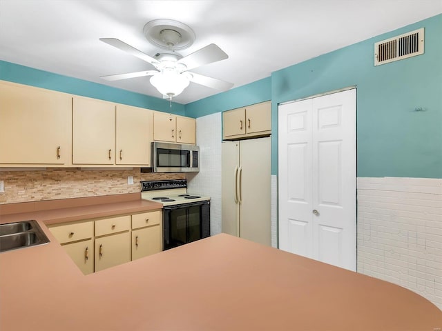 kitchen featuring white appliances, backsplash, cream cabinets, sink, and ceiling fan