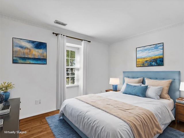 bedroom featuring crown molding and dark wood-type flooring