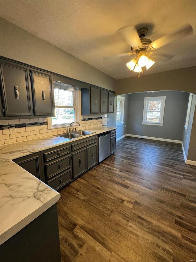 kitchen with dishwasher, sink, tasteful backsplash, and dark hardwood / wood-style floors