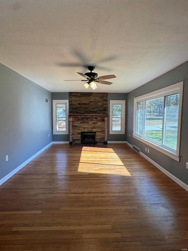 unfurnished living room featuring dark hardwood / wood-style flooring, a wealth of natural light, and a textured ceiling