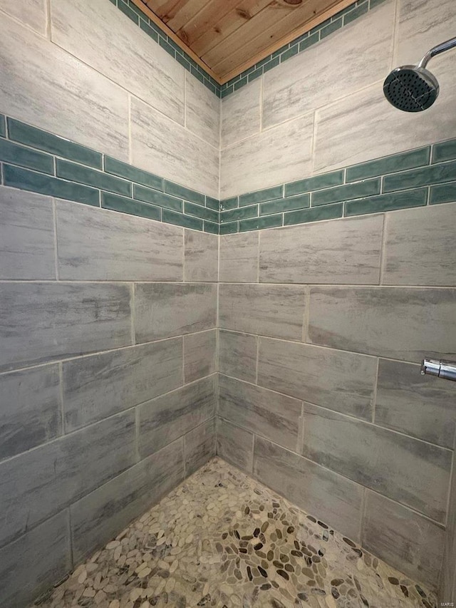 bathroom featuring a tile shower and wood ceiling