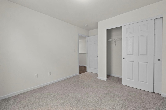 unfurnished bedroom with light carpet and a closet