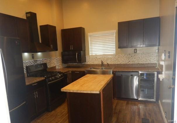 kitchen with sink, black appliances, decorative backsplash, and a center island