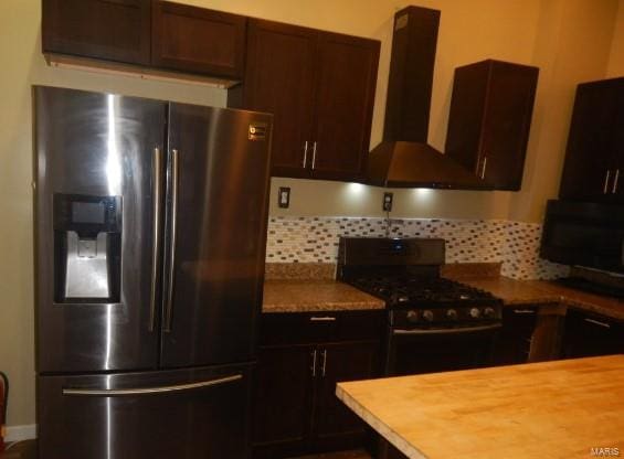 kitchen featuring ventilation hood, backsplash, stainless steel fridge with ice dispenser, dark brown cabinetry, and black range with gas cooktop