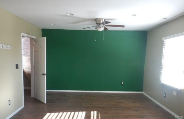 unfurnished room featuring dark hardwood / wood-style floors and ceiling fan