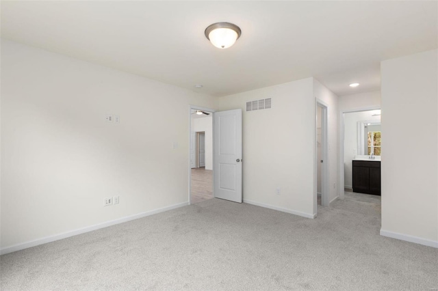 unfurnished bedroom with connected bathroom, a closet, and light colored carpet
