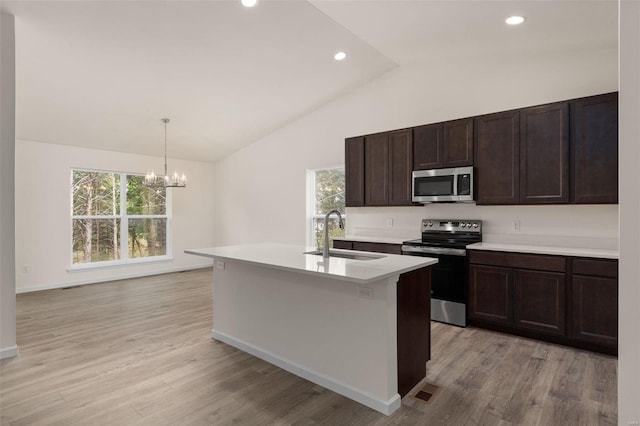 kitchen featuring stainless steel appliances, sink, an island with sink, light hardwood / wood-style floors, and lofted ceiling