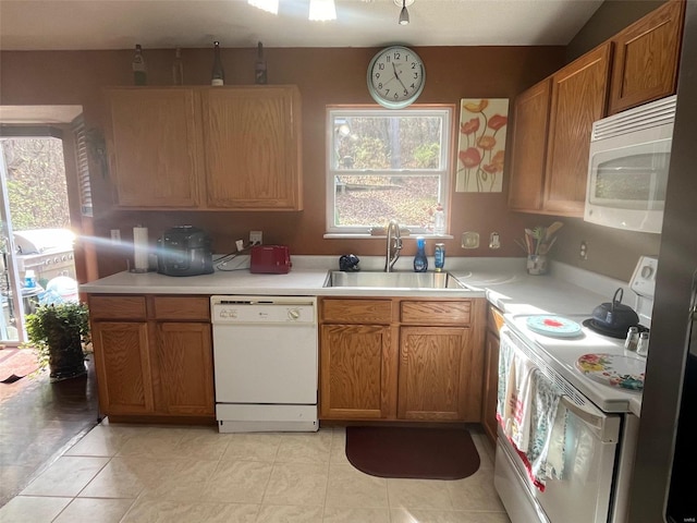 kitchen with white appliances, sink, and light tile patterned flooring