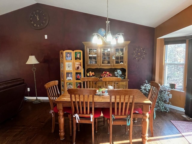 dining area with lofted ceiling, dark wood-type flooring, and a chandelier