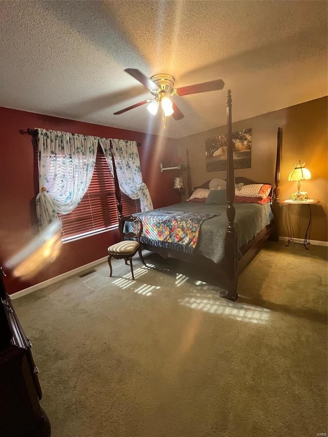 carpeted bedroom featuring ceiling fan and a textured ceiling