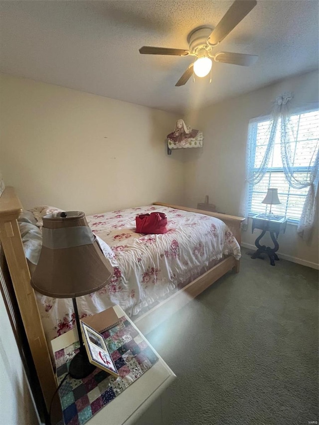 bedroom featuring ceiling fan, a textured ceiling, and carpet