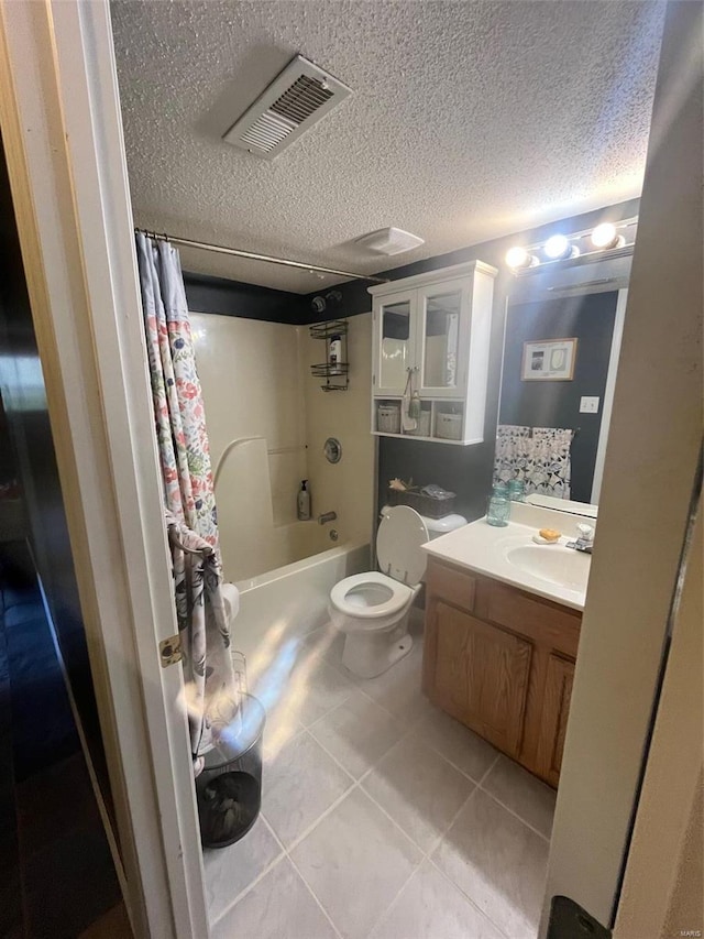 full bathroom with tile patterned flooring, shower / tub combo, a textured ceiling, vanity, and toilet