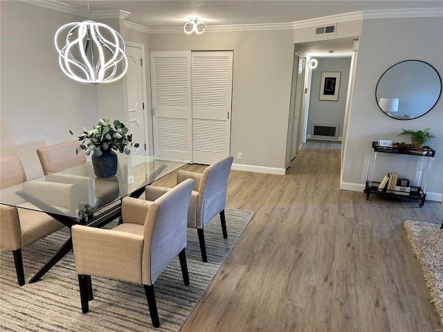 dining area with hardwood / wood-style floors, an inviting chandelier, crown molding, and a textured ceiling