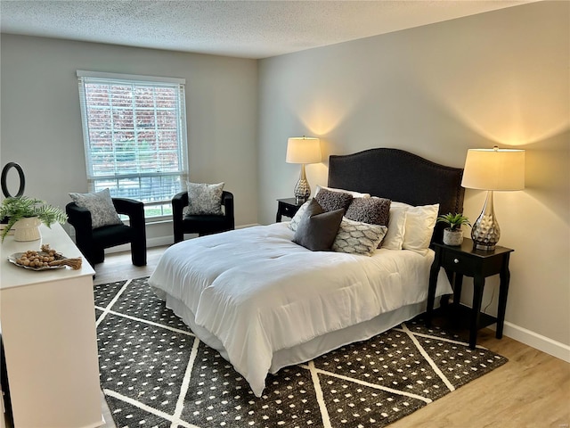 bedroom with a textured ceiling and hardwood / wood-style flooring