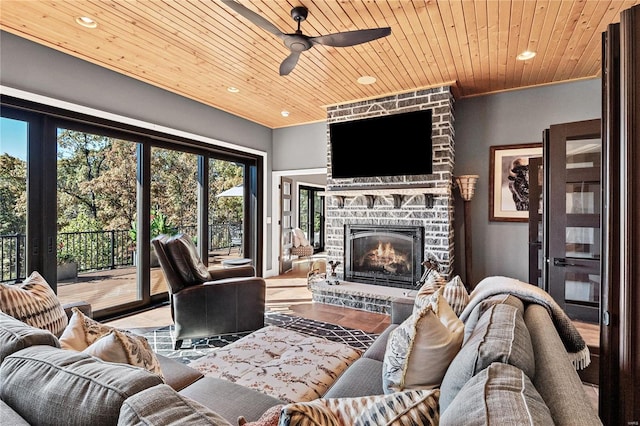 living room with wood-type flooring, crown molding, a fireplace, wooden ceiling, and ceiling fan