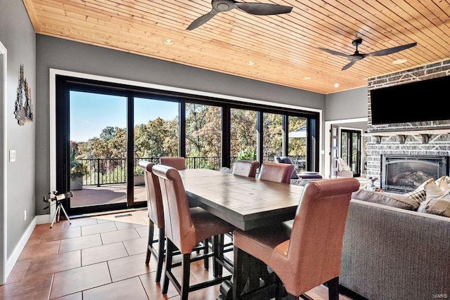 dining area featuring a fireplace, light tile patterned floors, ceiling fan, and wooden ceiling