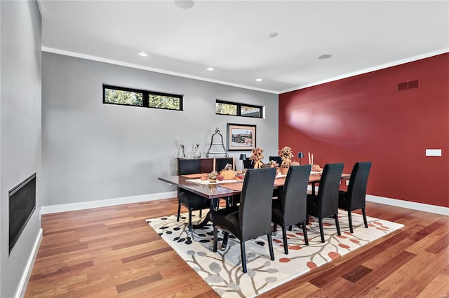 dining room featuring ornamental molding and light hardwood / wood-style flooring