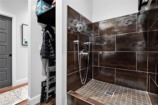 bathroom with wood-type flooring and a tile shower