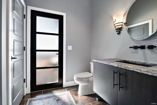 bathroom featuring tile patterned floors, vanity, and toilet