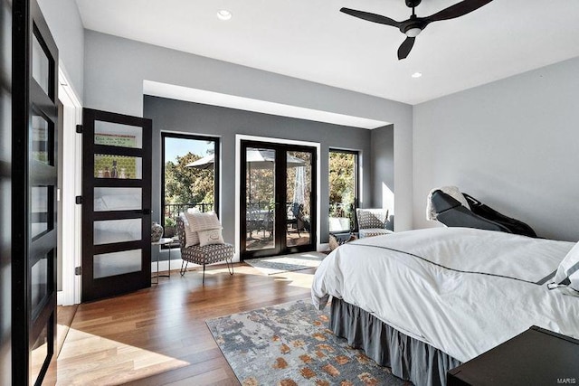 bedroom featuring hardwood / wood-style flooring, ceiling fan, multiple windows, and access to outside