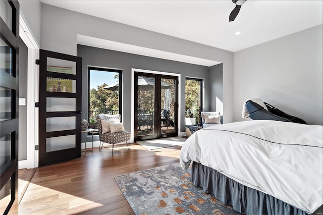 bedroom with hardwood / wood-style flooring, access to exterior, multiple windows, and ceiling fan