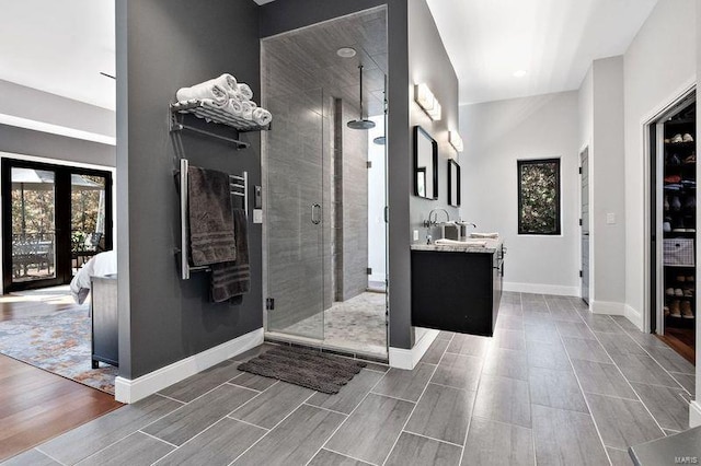 bathroom with a shower with shower door and vanity