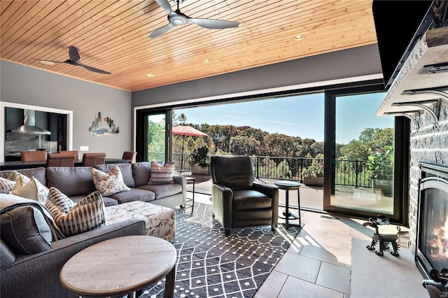 interior space with a fireplace, ceiling fan, and wood ceiling