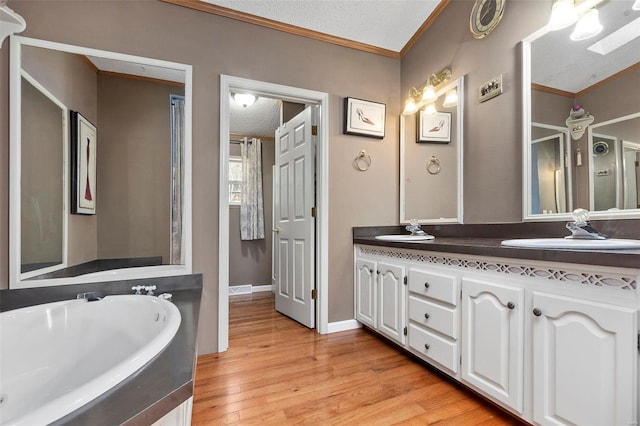 bathroom featuring hardwood / wood-style flooring, vanity, ornamental molding, and a textured ceiling