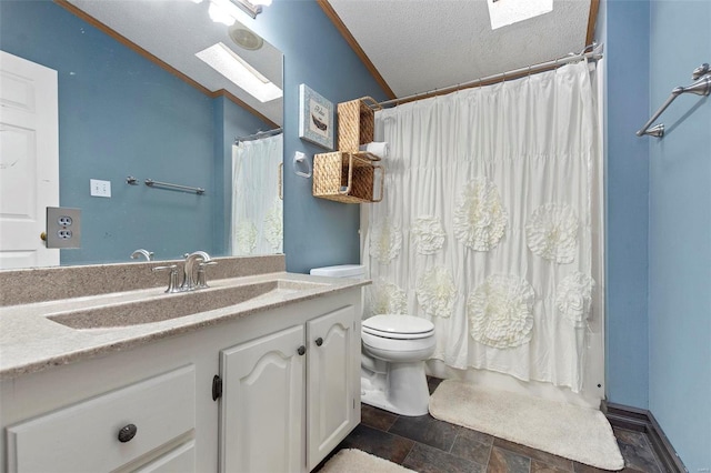 bathroom with vanity, a skylight, toilet, ornamental molding, and a textured ceiling