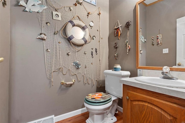 bathroom with hardwood / wood-style floors, vanity, and toilet