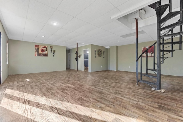 interior space featuring a drop ceiling and wood-type flooring