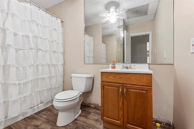 bathroom with vanity, ceiling fan, wood-type flooring, toilet, and curtained shower