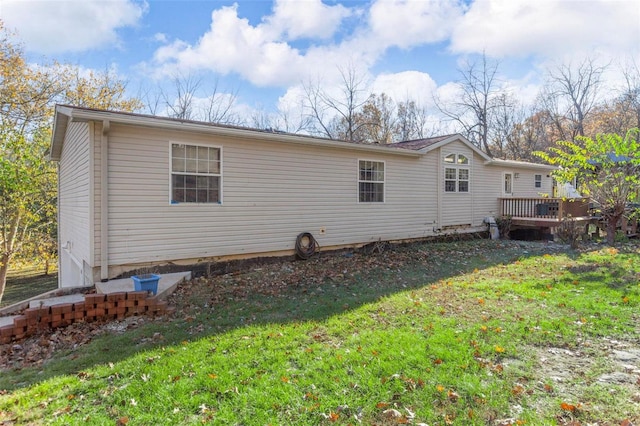 back of property with a lawn and a deck