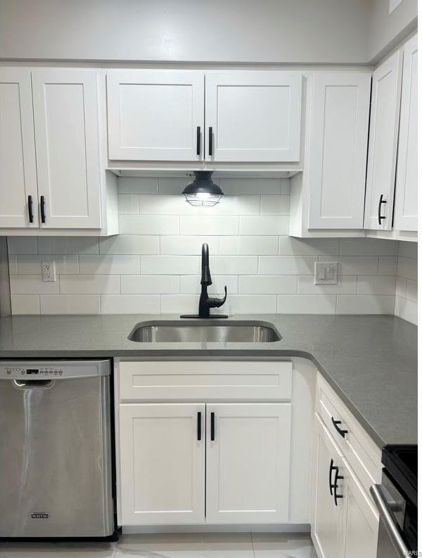 kitchen with white cabinets, decorative backsplash, sink, and stainless steel appliances