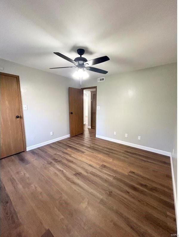 spare room with ceiling fan and dark hardwood / wood-style flooring