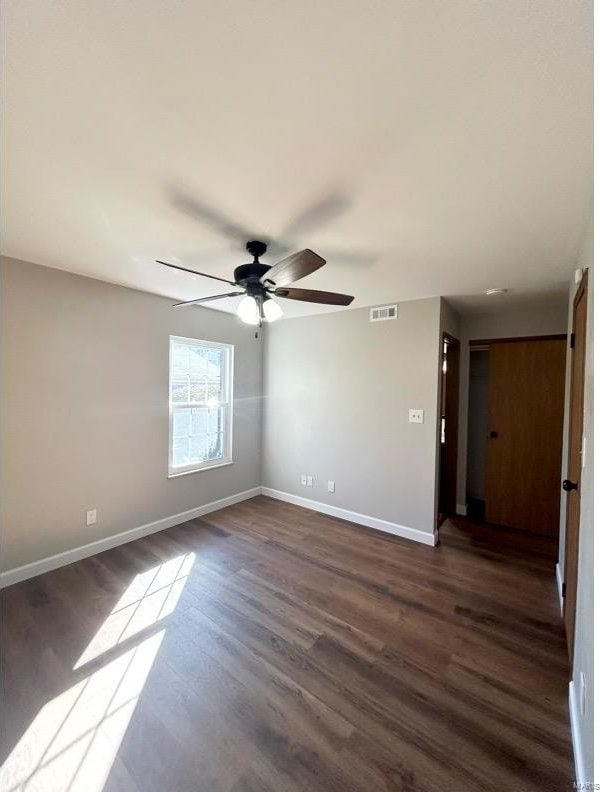 spare room with ceiling fan and dark hardwood / wood-style flooring