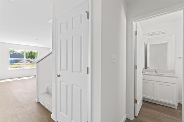 hallway with sink and light wood-type flooring