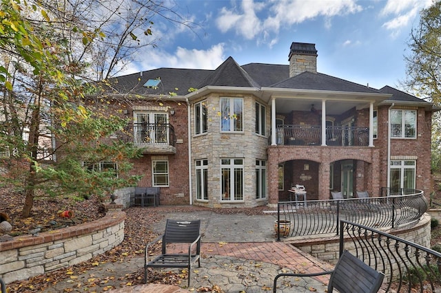 back of property with a balcony and a patio area