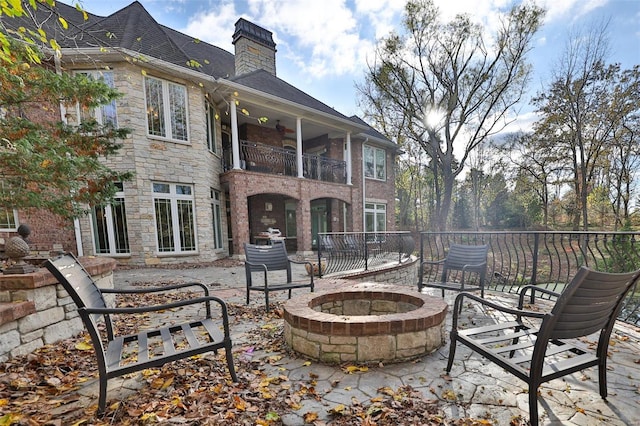 view of patio featuring a balcony and a fire pit